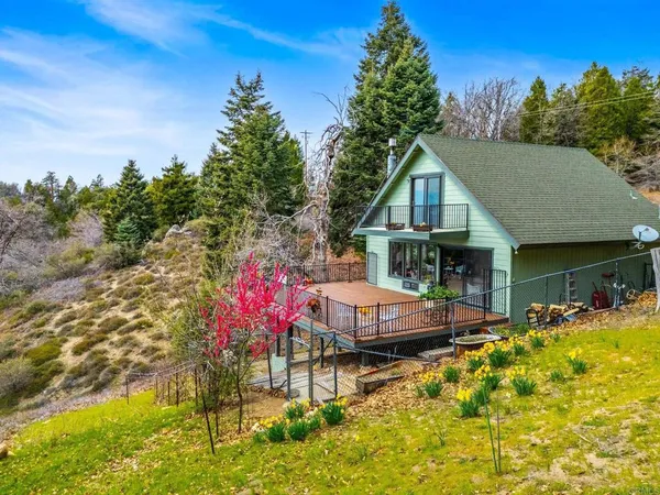 a front view of house with yard and trees in the background