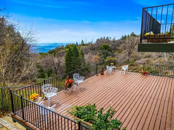 a view of a balcony with wooden floor and fence