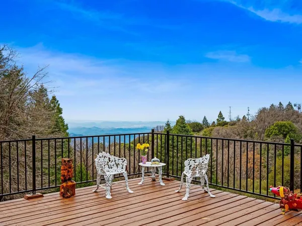 a view of balcony with wooden floor and fence