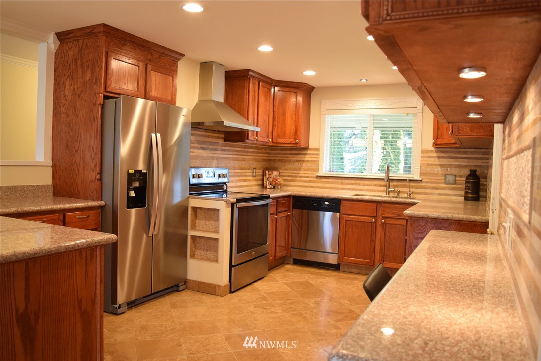 703 Bing Road, Unit A Lynnwood, WA 98036 - Photo 3 of 13 a kitchen with stainless steel appliances granite countertop a refrigerator a sink a stove and a microwave