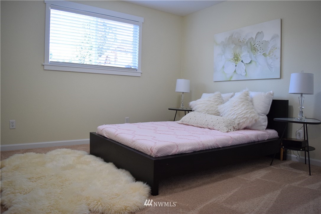 703 Bing Road, Unit A Lynnwood, WA 98036 - Photo 9 of 13 a bedroom with a bed and a painting on the wall