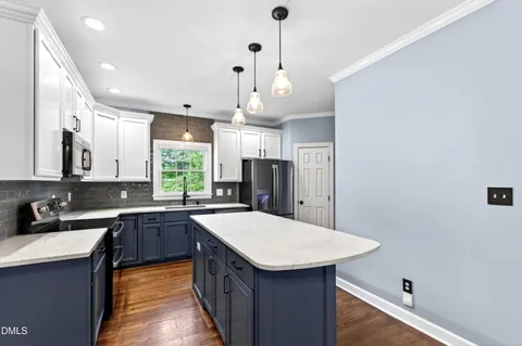 a view of a big room with wooden floor and a kitchen