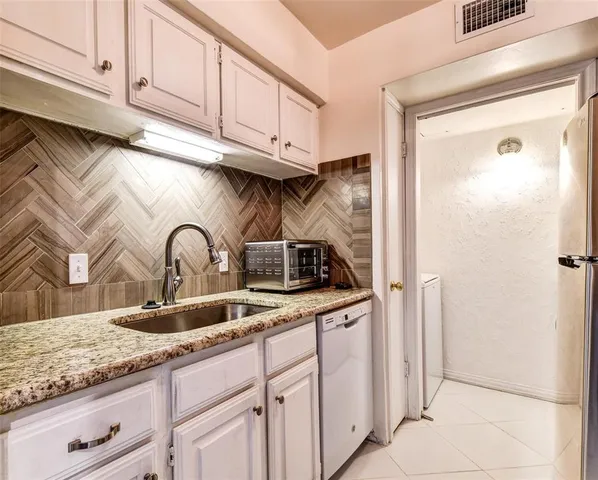 a kitchen with granite countertop a sink and cabinets