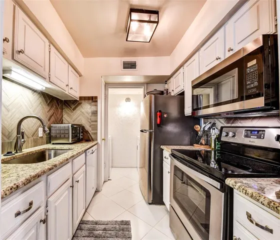 a kitchen with stainless steel appliances granite countertop a stove sink and refrigerator
