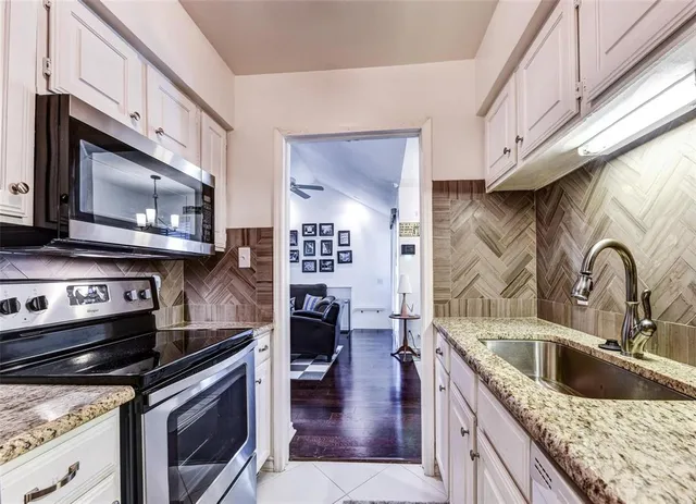 a kitchen with stainless steel appliances granite countertop a stove a sink and a microwave