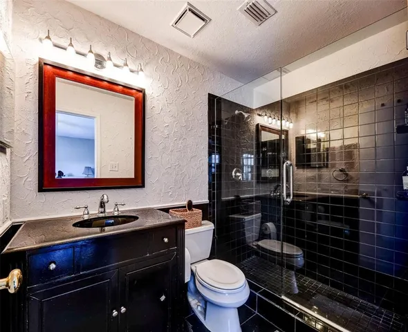 a bathroom with a toilet sink and mirror