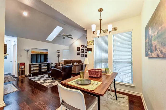 a dining room with furniture wooden floor a rug and a chandelier