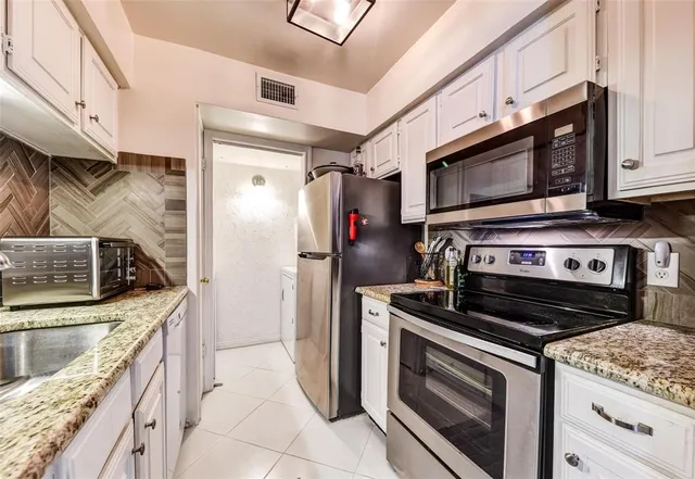 a kitchen with stainless steel appliances granite countertop a stove microwave and refrigerator