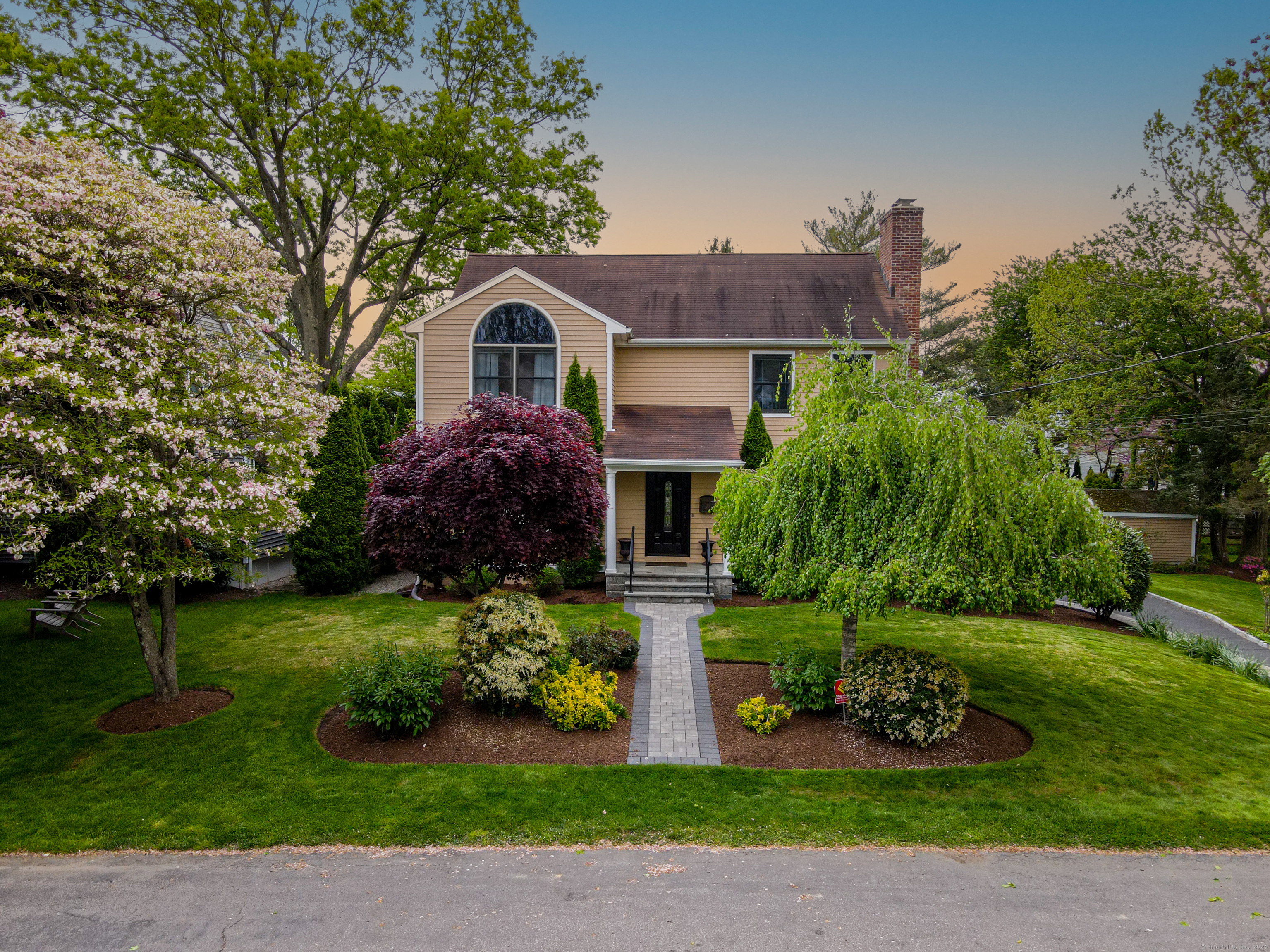 a front view of a house with a garden and plants