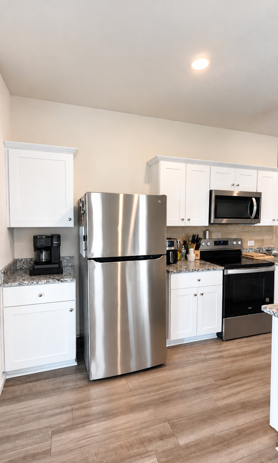Polished stone countertops complement crisp cabinetry and sleek stainless steel appliances.