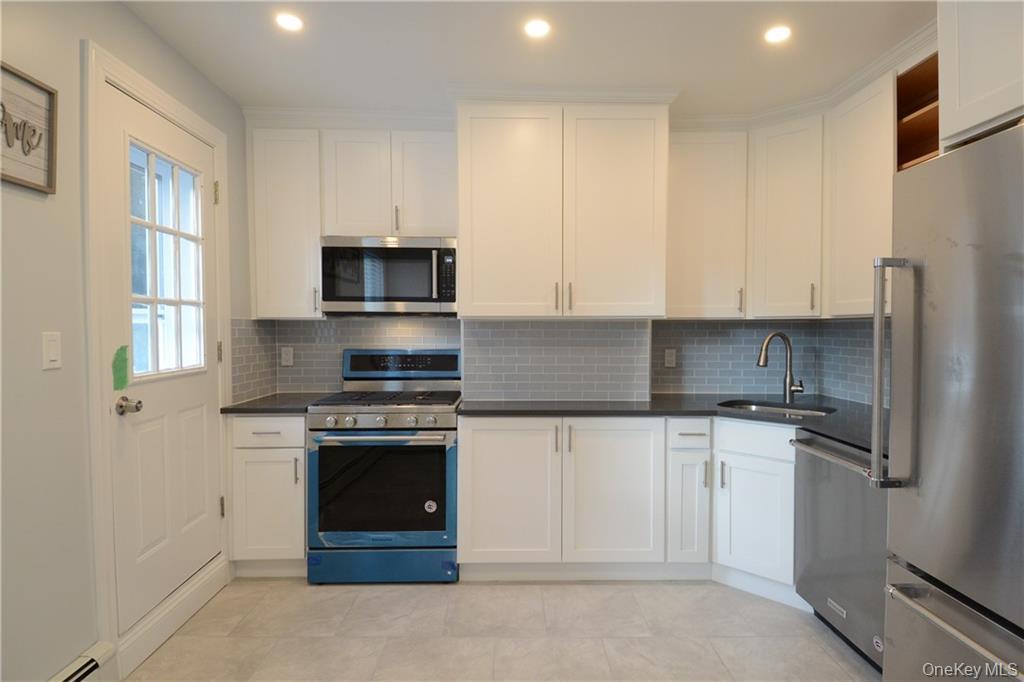 53 Dewitt Avenue, Unit 2 Bronxville, NY 10708 - Photo 8 of 19 a kitchen with granite countertop white cabinets and stainless steel appliances