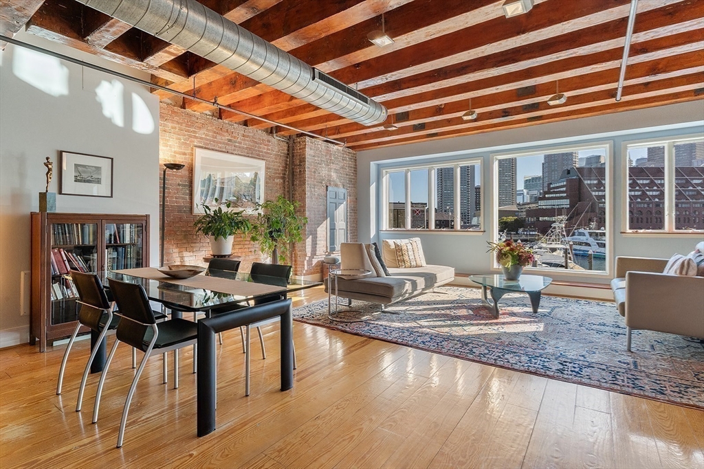 59 Commercial Wharf, Unit 1 Boston, MA 02110 - Photo 1 of 19 a living room with furniture and a wooden floor