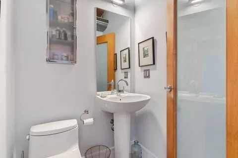a bathroom with a sink mirror and toilet