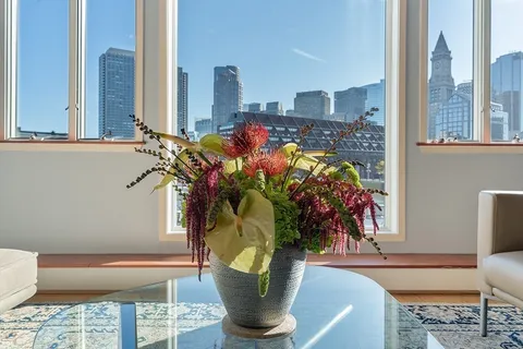 a vase of flowers sitting on a table with window