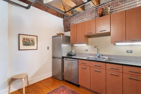 a kitchen with stainless steel appliances granite countertop a sink refrigerator and cabinets
