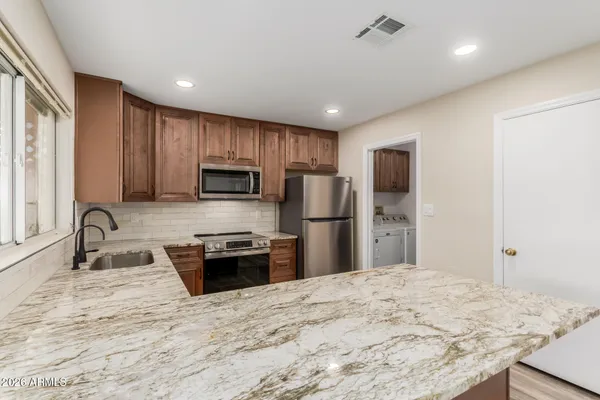 a kitchen with stainless steel appliances granite countertop a sink refrigerator and microwave