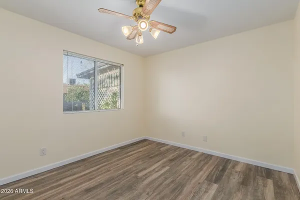an empty room with a window and ceiling fan