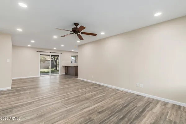 a view of empty room with wooden floor and window