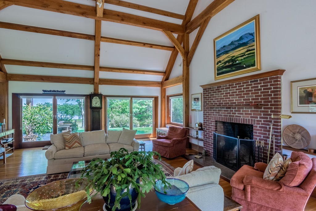 440 Snipatuit Road Rochester, MA 02770 - Photo 8 of 30 a living room with furniture a fireplace and a floor to ceiling window
