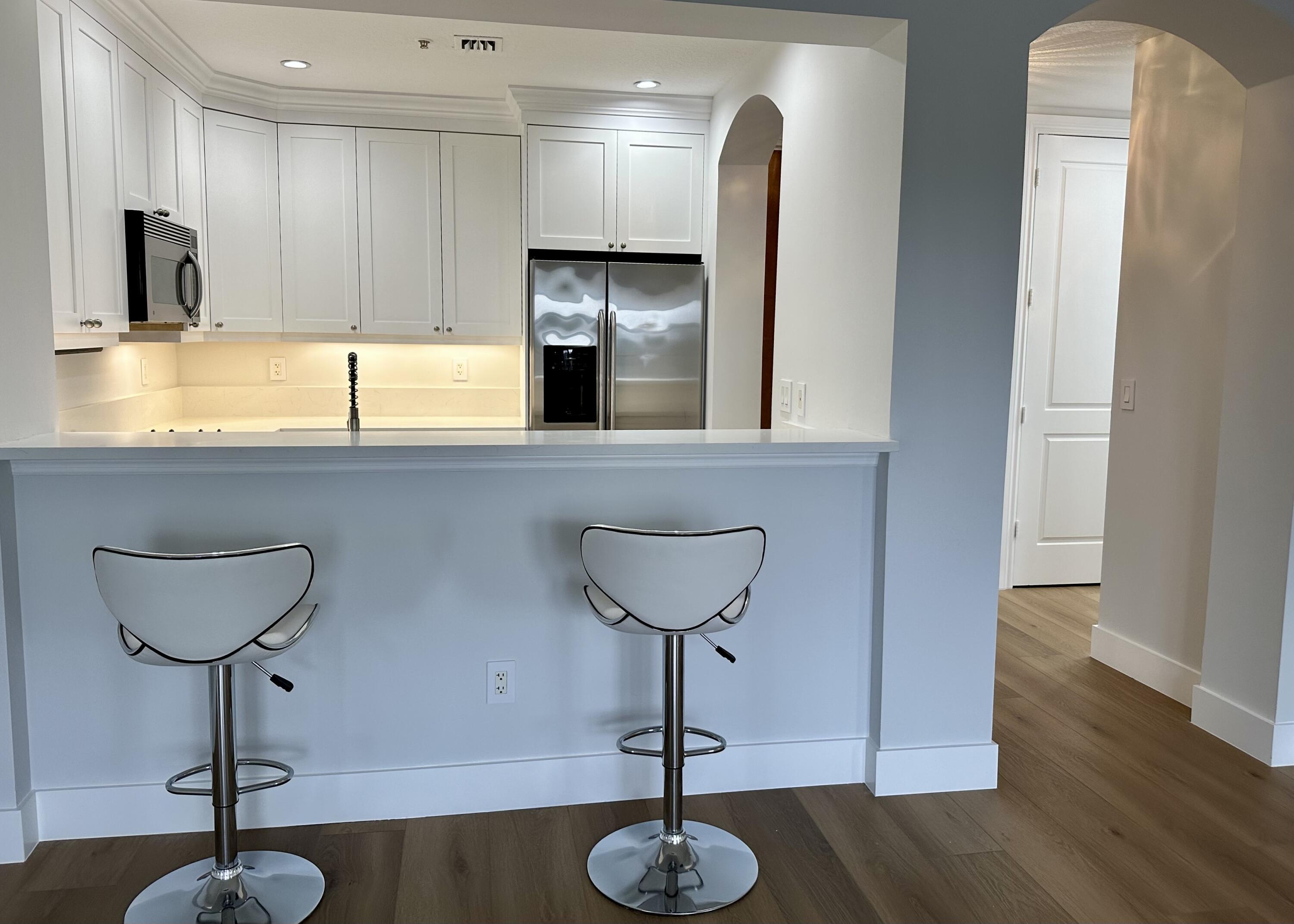 200 Northeast 2nd Avenue, Unit 312 Delray Beach, FL 33444 - Photo 11 of 30 a kitchen with stainless steel appliances a sink cabinets and wooden floor
