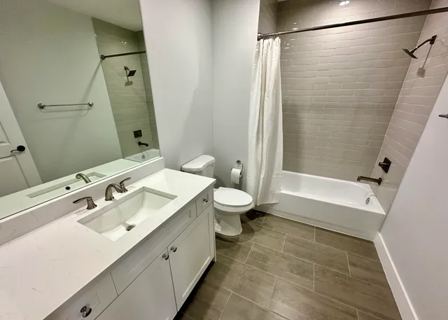 a bathroom with a double vanity sink toilet and shower