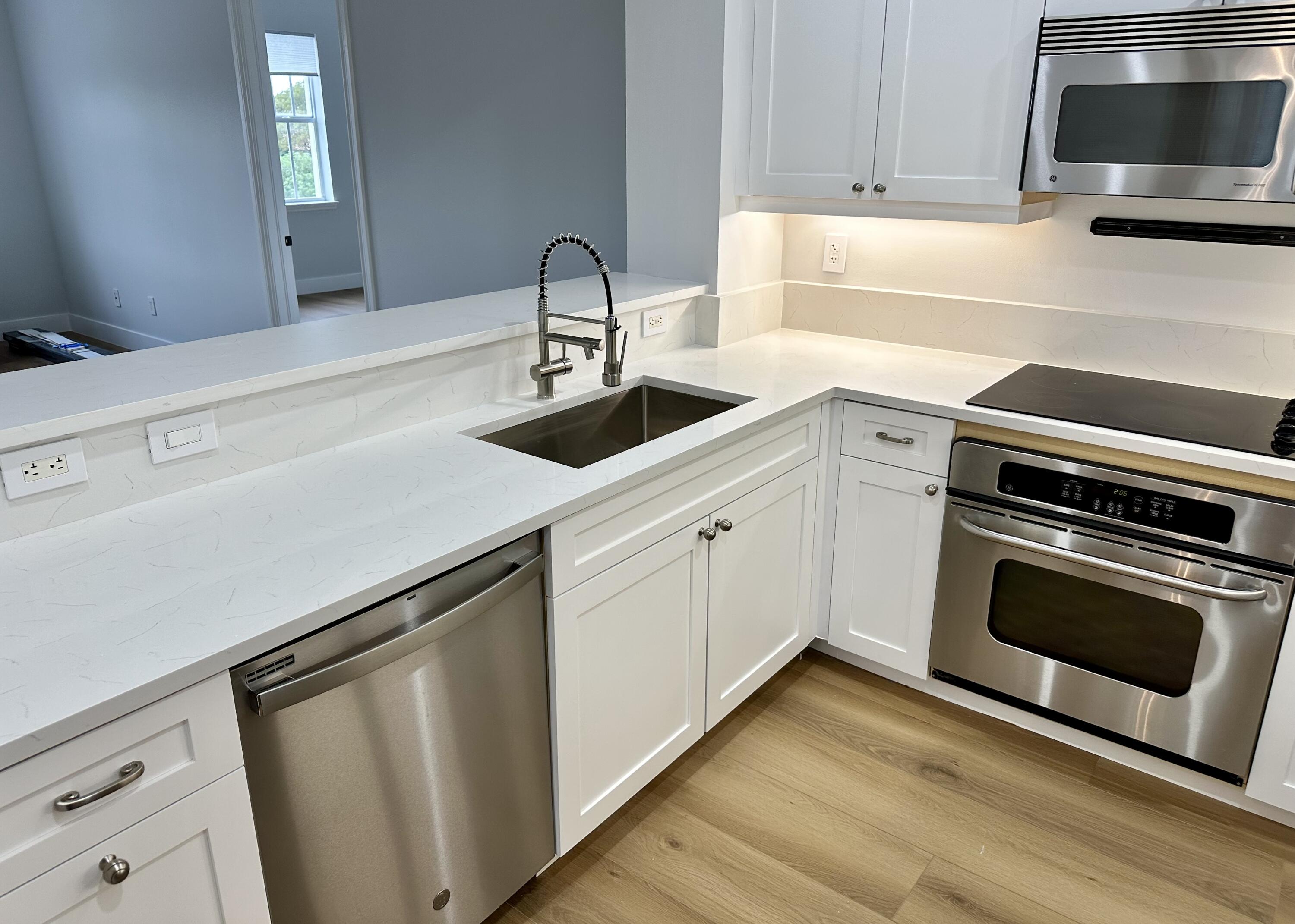 200 Northeast 2nd Avenue, Unit 312 Delray Beach, FL 33444 - Photo 9 of 30 a kitchen with a sink cabinets and stainless steel appliances