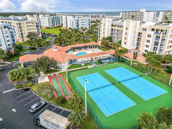 a view of a white house with a yard and table and chairs