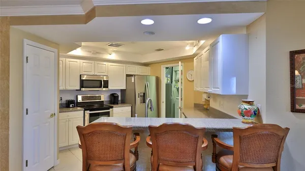 a view of a dining room with furniture a chandelier and large windows
