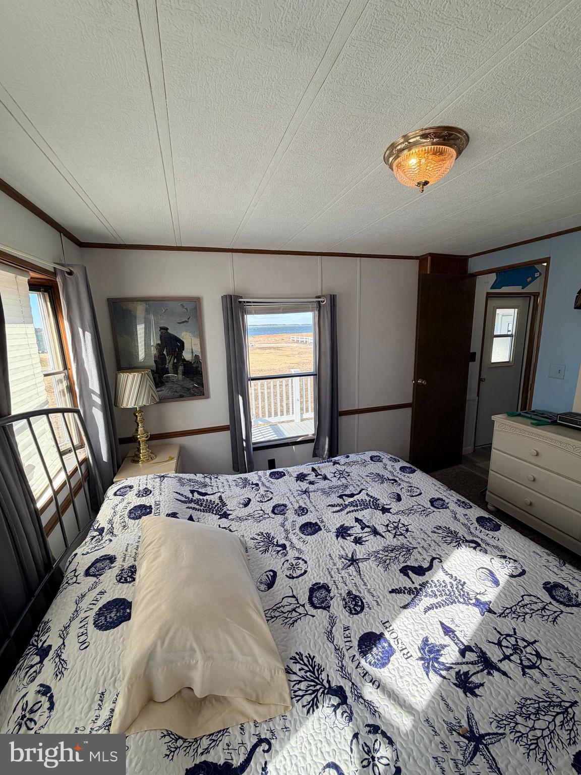 38267 Possum Road, Unit 271 Ocean View, DE 19970 - Photo 24 of 75 a bedroom with a large bed and a dresser