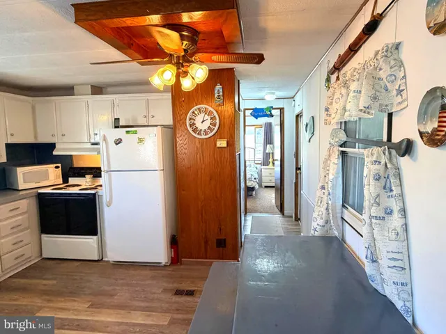 a kitchen with white cabinets and white appliances