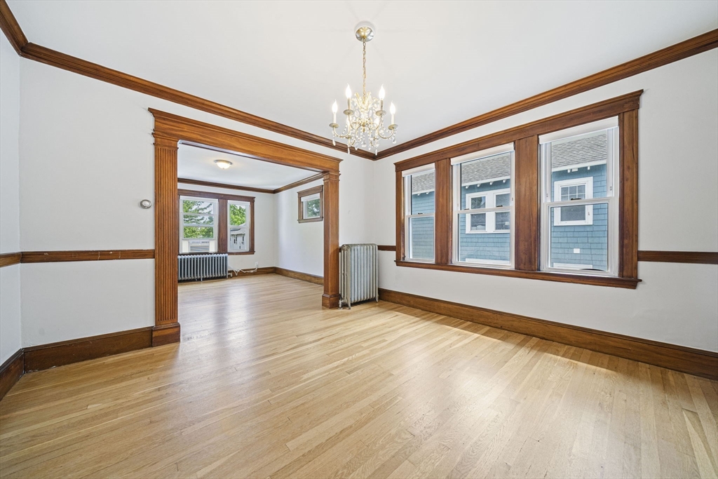 104 Greaton Road, Unit 2 Boston, MA 02132 - Photo 2 of 32 a view of an empty room with window and wooden floor