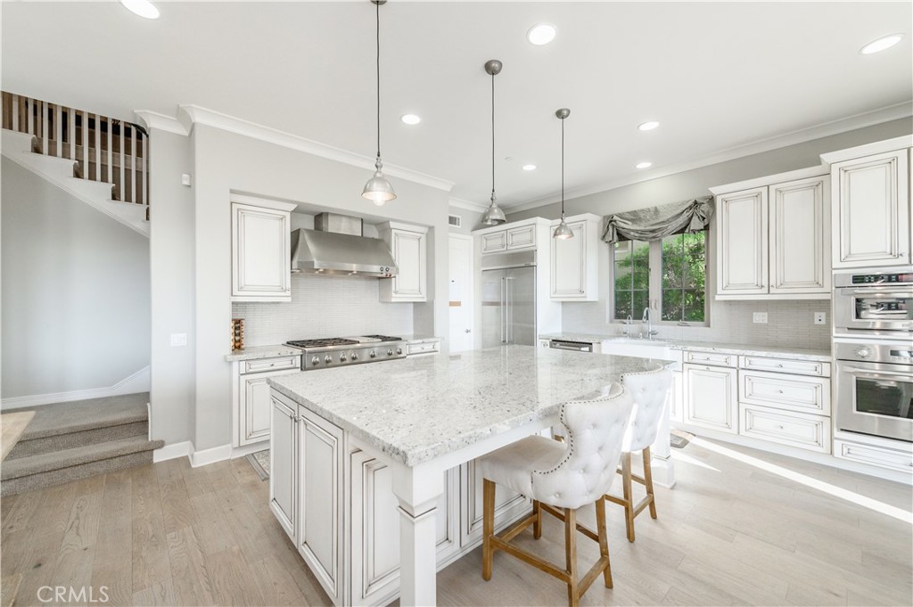 126 Long Fence Irvine, CA 92602 - Photo 12 of 61 a kitchen with kitchen island a stove a table and chairs in it