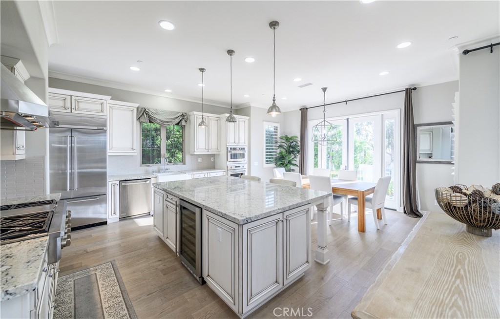 126 Long Fence Irvine, CA 92602 - Photo 4 of 61 a kitchen with stainless steel appliances granite countertop a stove a sink a oven and a dining table with wooden floor