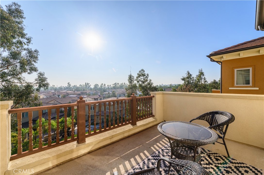 126 Long Fence Irvine, CA 92602 - Photo 52 of 61 a balcony with wooden floor table and chairs