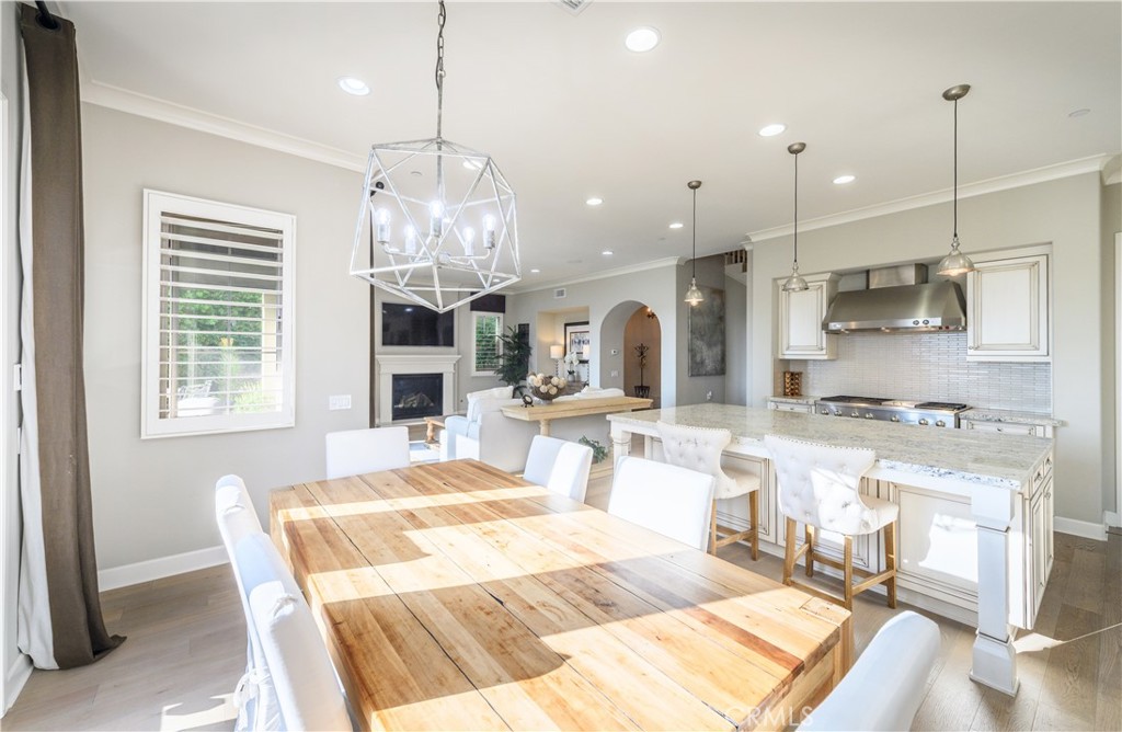 126 Long Fence Irvine, CA 92602 - Photo 9 of 61 a large kitchen with kitchen island granite countertop a stove a sink a dining table and chairs with wooden floor