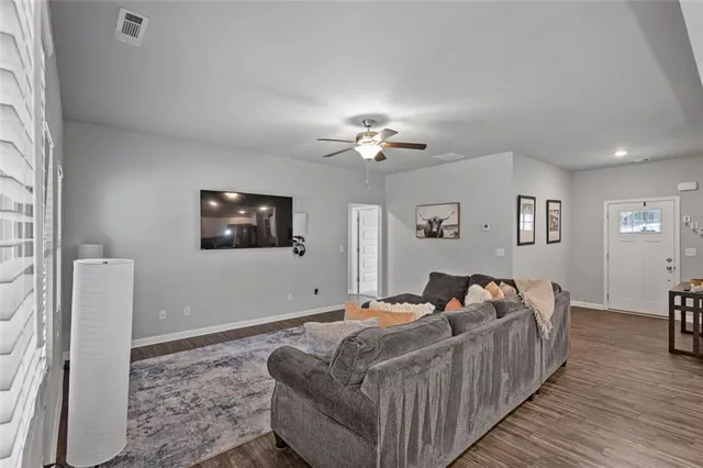 a open kitchen with stainless steel appliances granite countertop a stove top oven a refrigerator a sink and a dining table with wooden floor