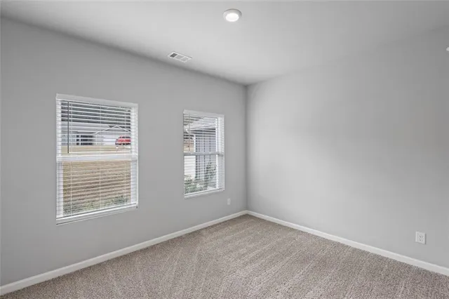 a bathroom with a granite countertop sink vanity mirror and toilet