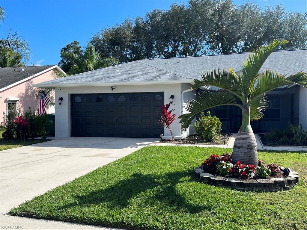 480 St Andrews Boulevard, Unit 14 Naples, FL 34113 - Photo 1 of 24 a front view of a house with a garden