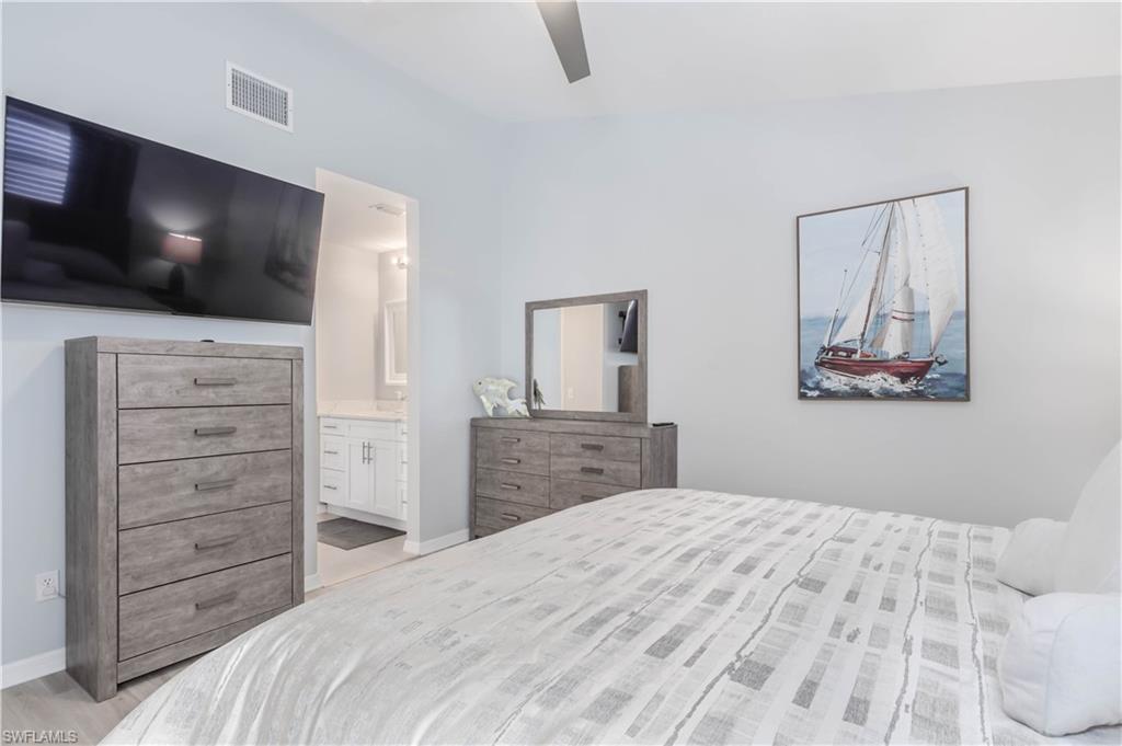 480 St Andrews Boulevard, Unit 14 Naples, FL 34113 - Photo 14 of 24 a bedroom with a bed and a flat screen tv in white walls