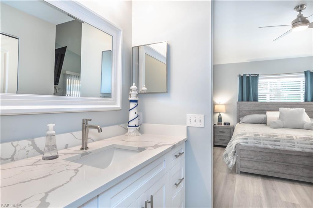 480 St Andrews Boulevard, Unit 14 Naples, FL 34113 - Photo 15 of 24 a bedroom with a bed and a mirror