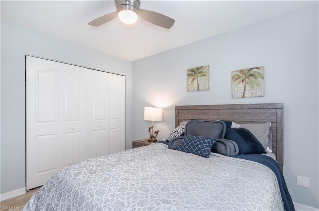 480 St Andrews Boulevard, Unit 14 Naples, FL 34113 - Photo 17 of 24 a bedroom with a bed and a chandelier