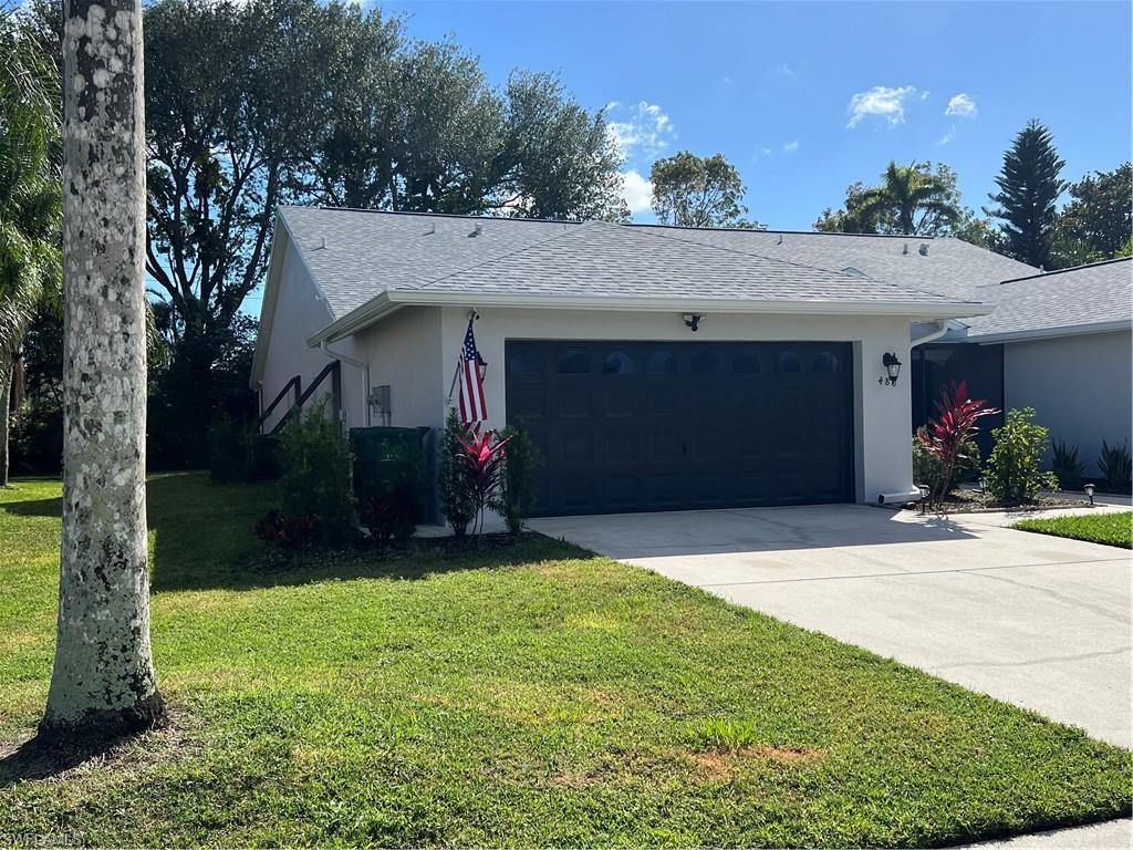 480 St Andrews Boulevard, Unit 14 Naples, FL 34113 - Photo 2 of 24 a front view of a house with a yard and a garage