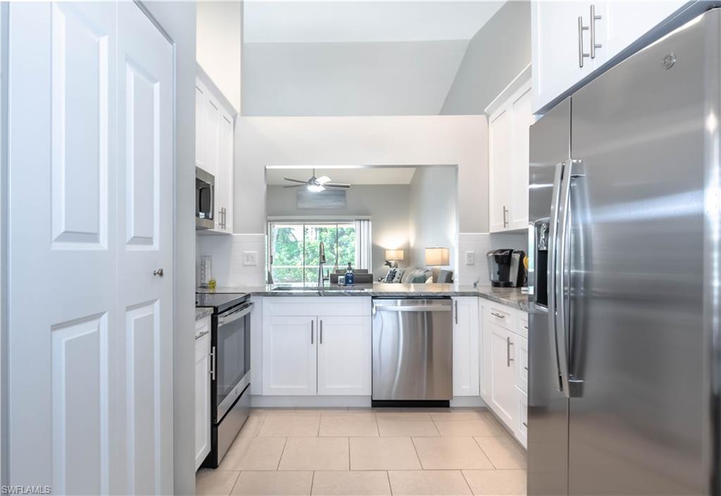 480 St Andrews Boulevard, Unit 14 Naples, FL 34113 - Photo 8 of 24 a kitchen with stainless steel appliances granite countertop a refrigerator and a sink