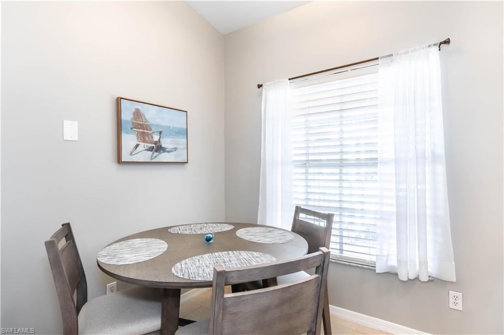 480 St Andrews Boulevard, Unit 14 Naples, FL 34113 - Photo 10 of 24 a dining room with furniture and window