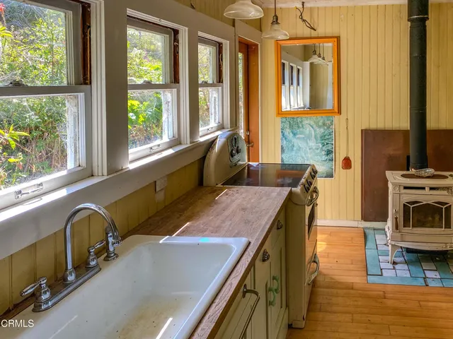 a view of a hallway with wooden floor and a window