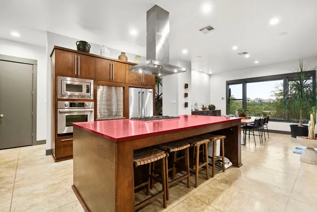 a large kitchen with stainless steel appliances kitchen island granite countertop a table and chairs
