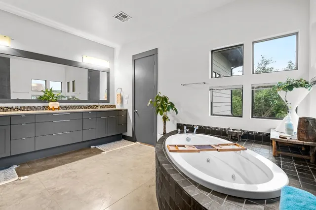 a spacious bathroom with a granite countertop tub sink and mirror