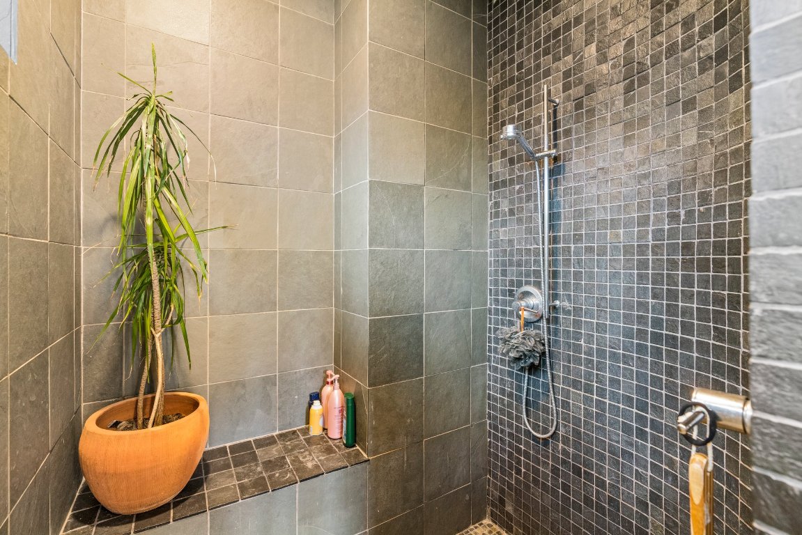 332 Rugged Earth Drive, Unit 1 Austin, TX 78737 - Photo 16 of 32 a bathroom with a sink and blue shower