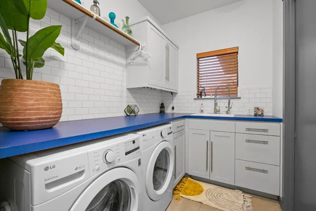 a utility room with cabinets and washer
