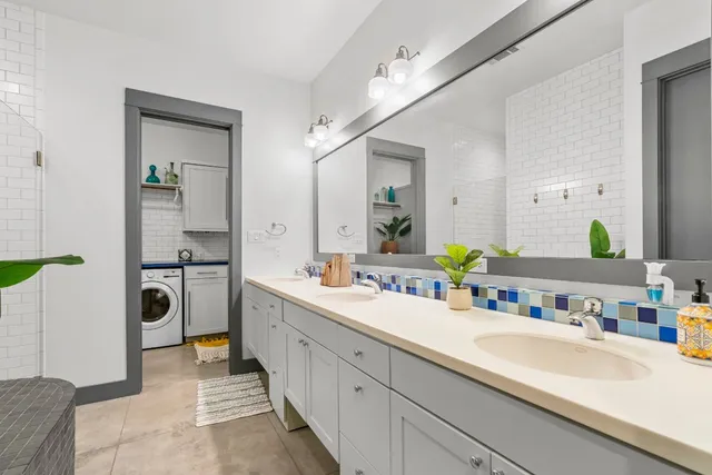 a en suite bathroom with a double vanity sink a mirror and shower